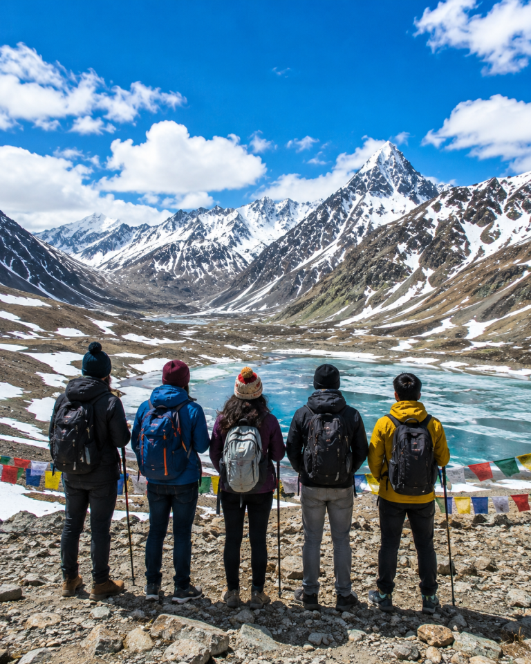 Tourists enjoying breathtaking views of snow-covered mountains and Suraj Tal Lake at Baralacha Pass on the Manali-Leh Highway